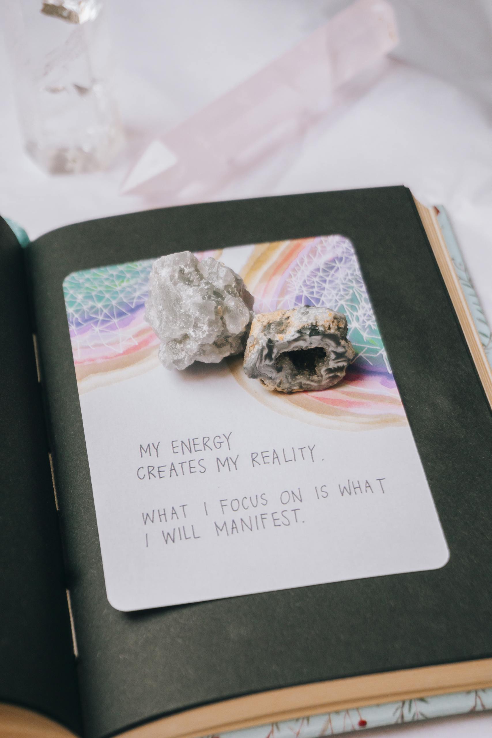 Open journal featuring crystals and an inspiring manifestation quote, perfect for motivation seekers.